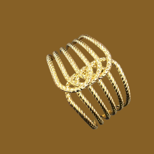 Gold bracelets on a wrist with a blurred background
